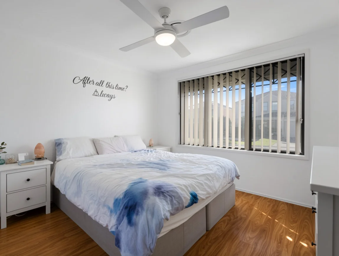 Bright private bedroom with timber floors and a ceiling fan at the Oakhurst home