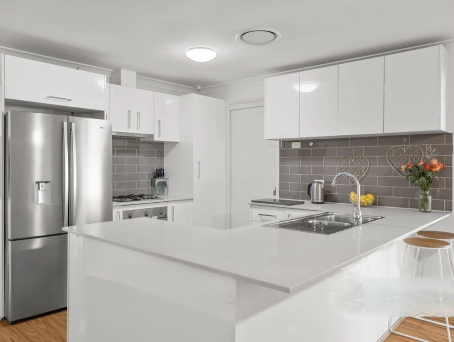 Modern white kitchen with stone benchtops at the Oakhurst home